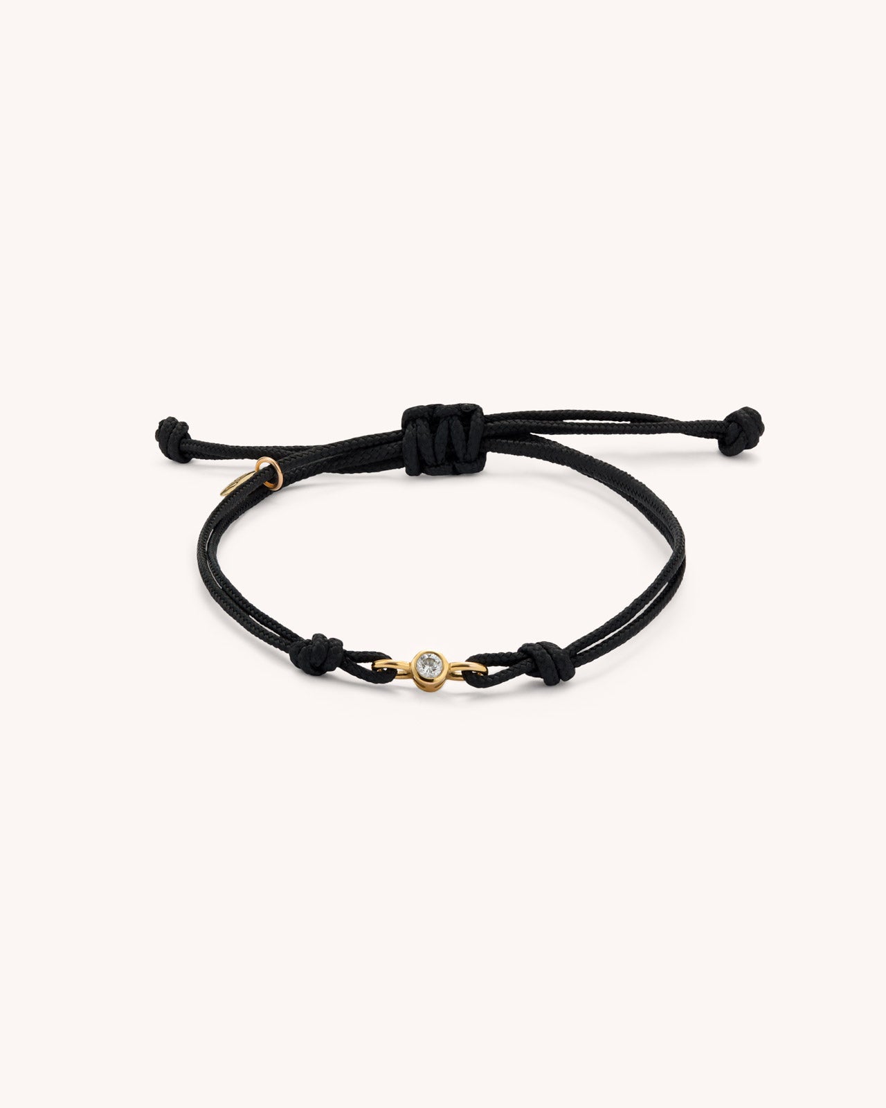 EIEN bracelet with double black cord and central lab-grown diamond set in gold vermeil, product photo on neutral background.