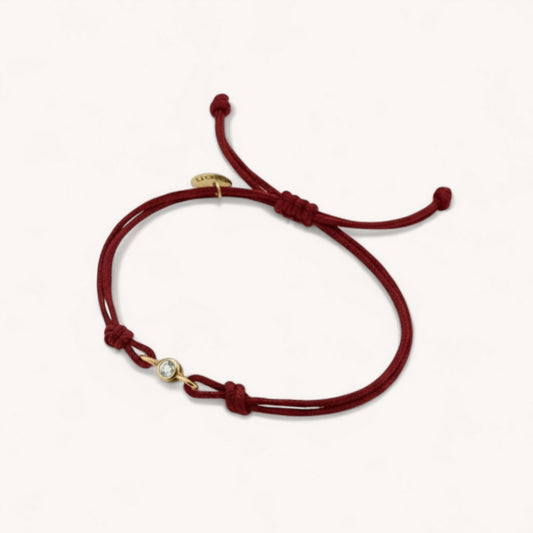  bracelet showing the lab-grown diamond bezel set in gold
vermeil with double burgundy cord detail.
